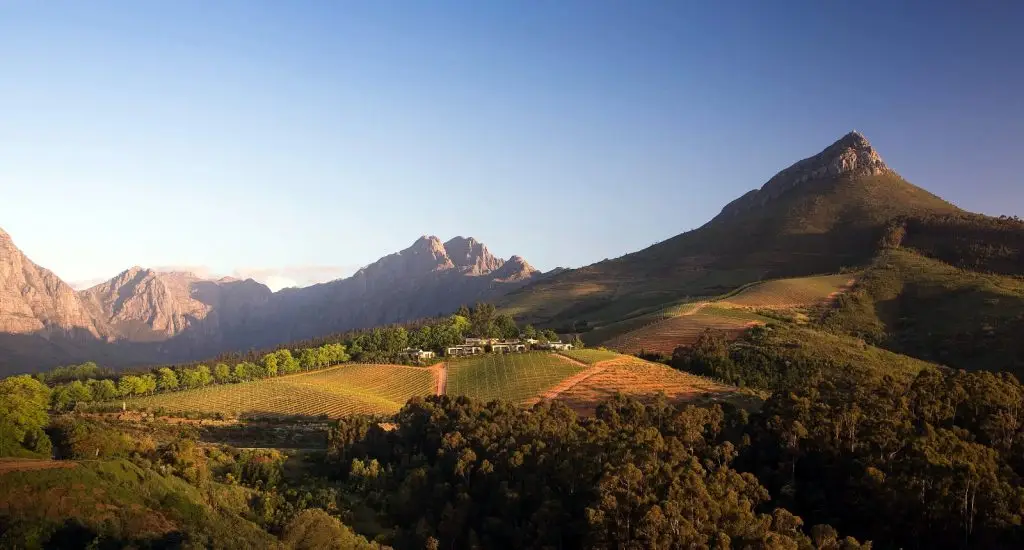 panoramic view of Delaire Graff Wine Estate against mountain backdrop