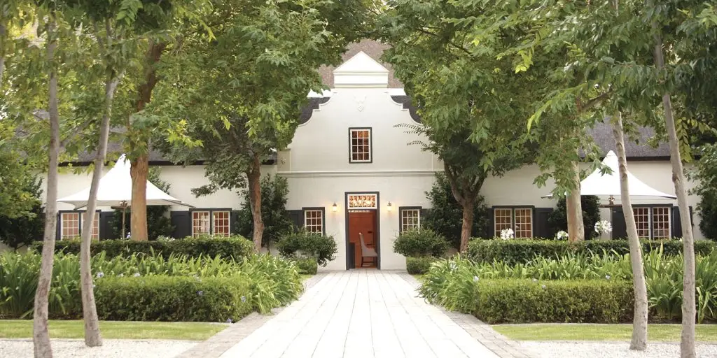 gracious Cape Dutch gable surrounded by trees and manicured gardens at Grande Provence Wine Estate in Franschhoek valley