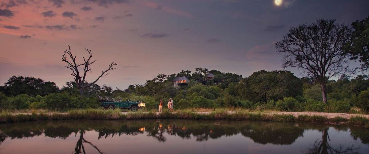Leopard Hills Lodge perched on a rocky outcrop overlooking a watering hole in Sabi Sand Reserve.
